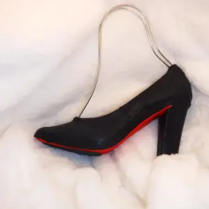 A black and red color heel sandle on a white cloth