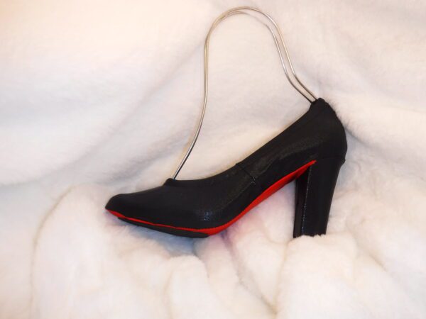 A black and red color heel sandle on a white cloth