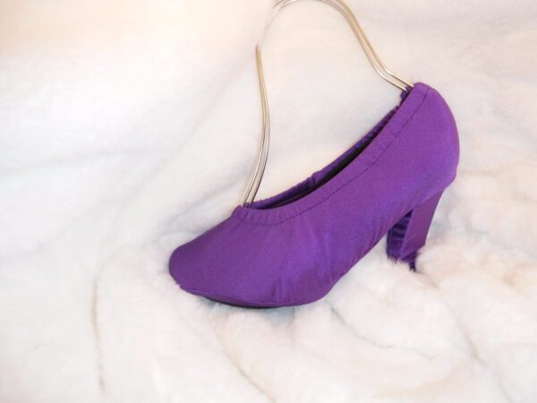 A purple color heel sandle cover on a white cloth