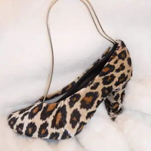 A tiger skin print heel sandle cover on a white sheet