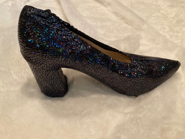 A blue sequin shoe cover on a white color sheet